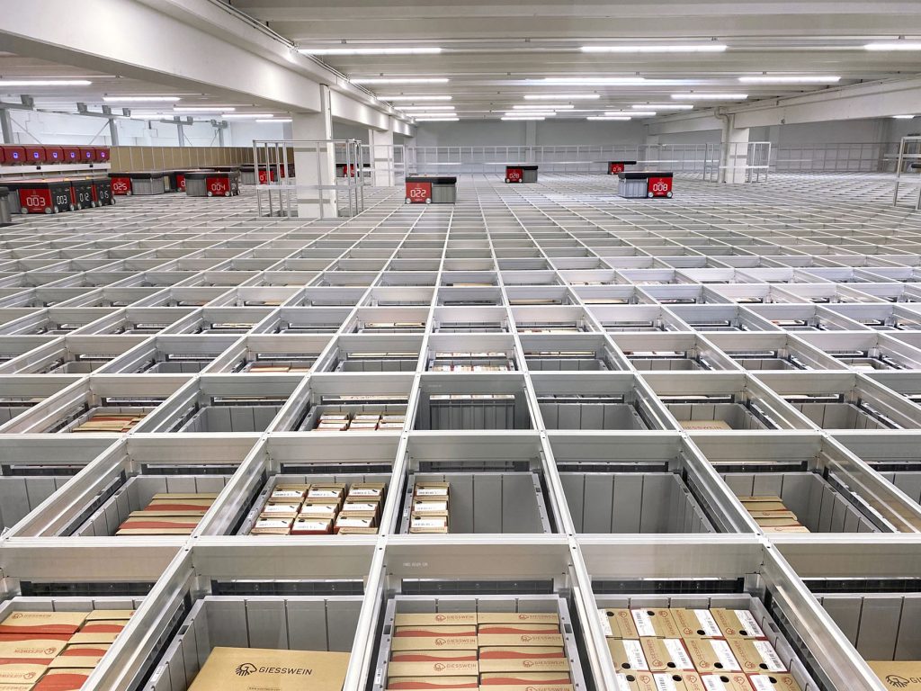 Hörmann Logistik realisierte bei Giesswein Walkwaren eine individuelle AutoStore Systemkonfiguration mit 31 Robotern und 17.500 Behältern auf neun Ebenen.